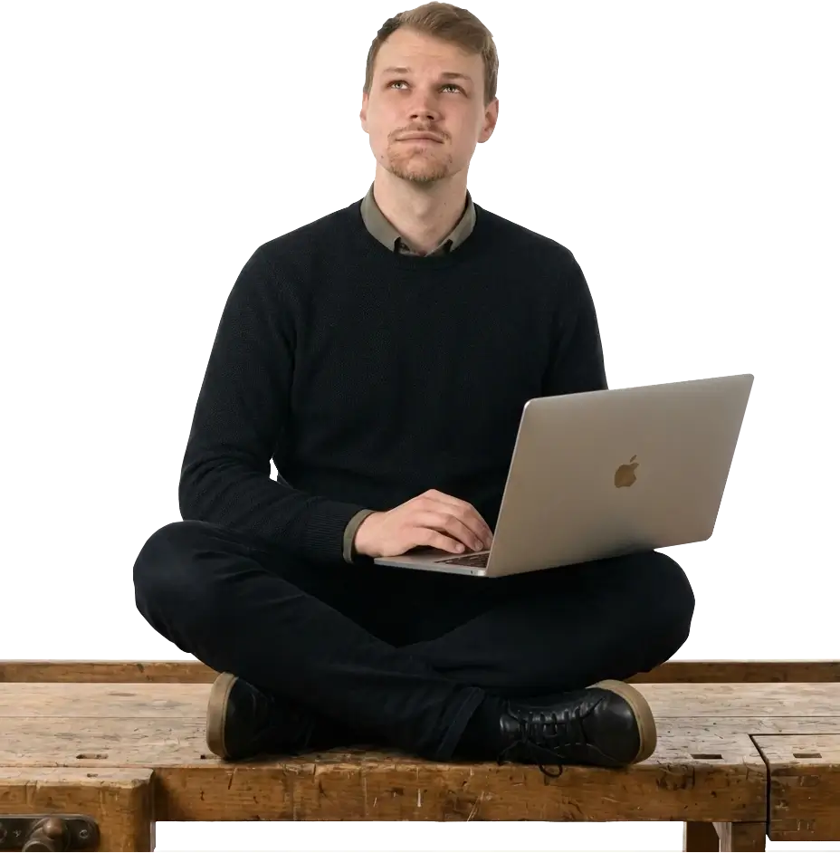 Christopher Matt Webentwickler Greppen Luzern - Mobile Hero Christopher Matt, Webentwickler aus Greppen (Luzern), blickt mit MacBook auf der Werkbank nach oben